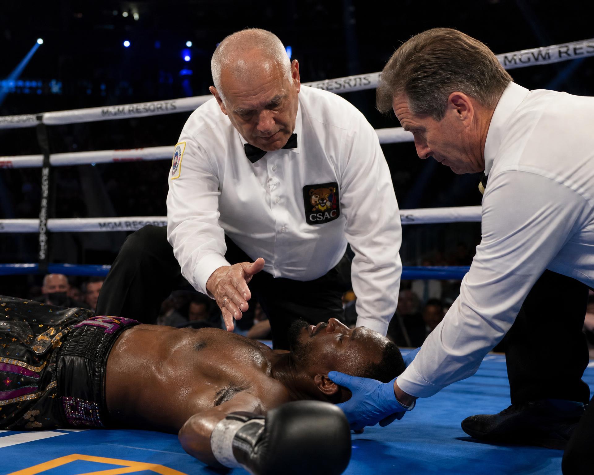 Referee counting over a fighter in the ring